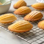 Golden Madeline Cookies Recipe Using Cream cooling on a rack.